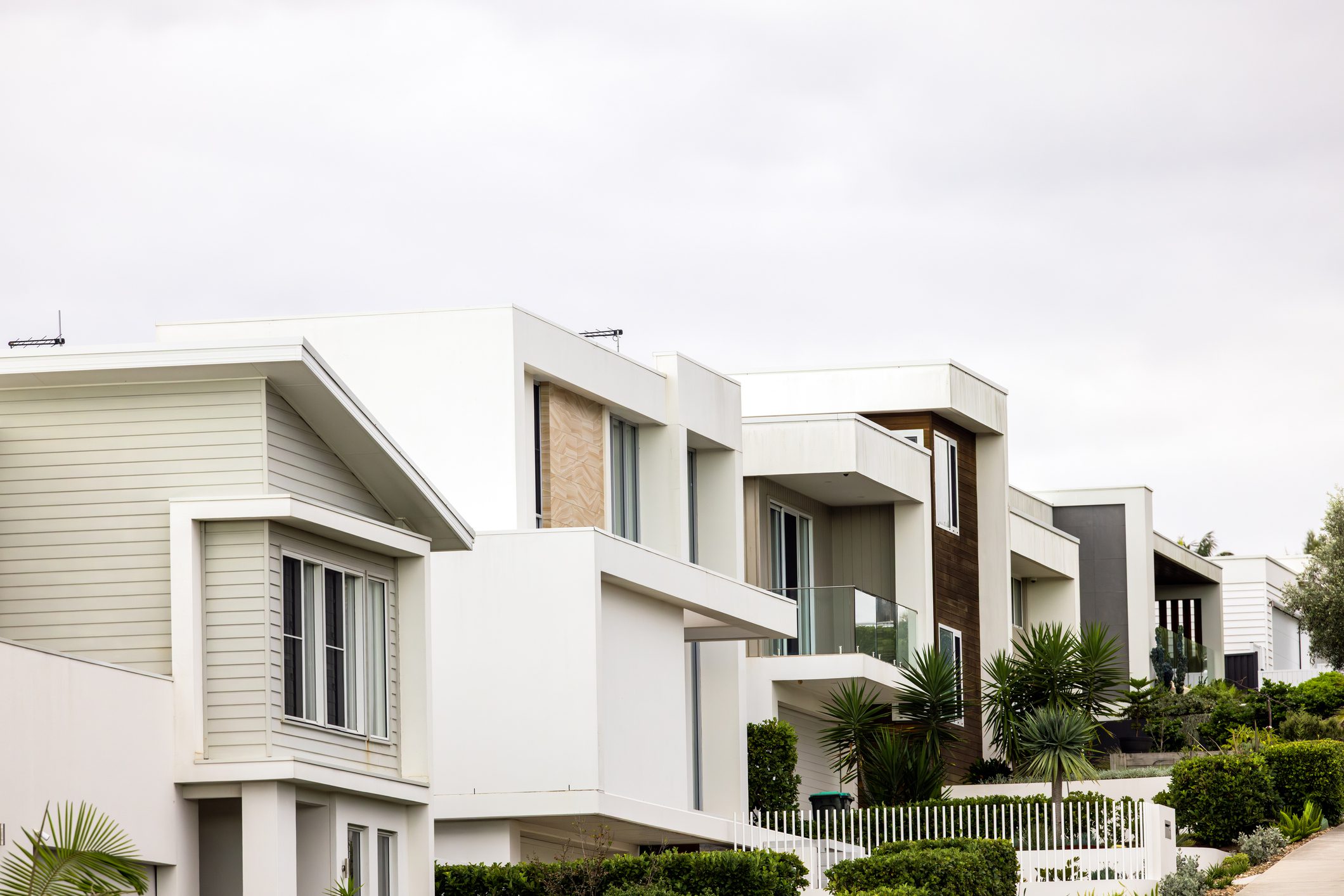 Row of modern white houses with landscaping