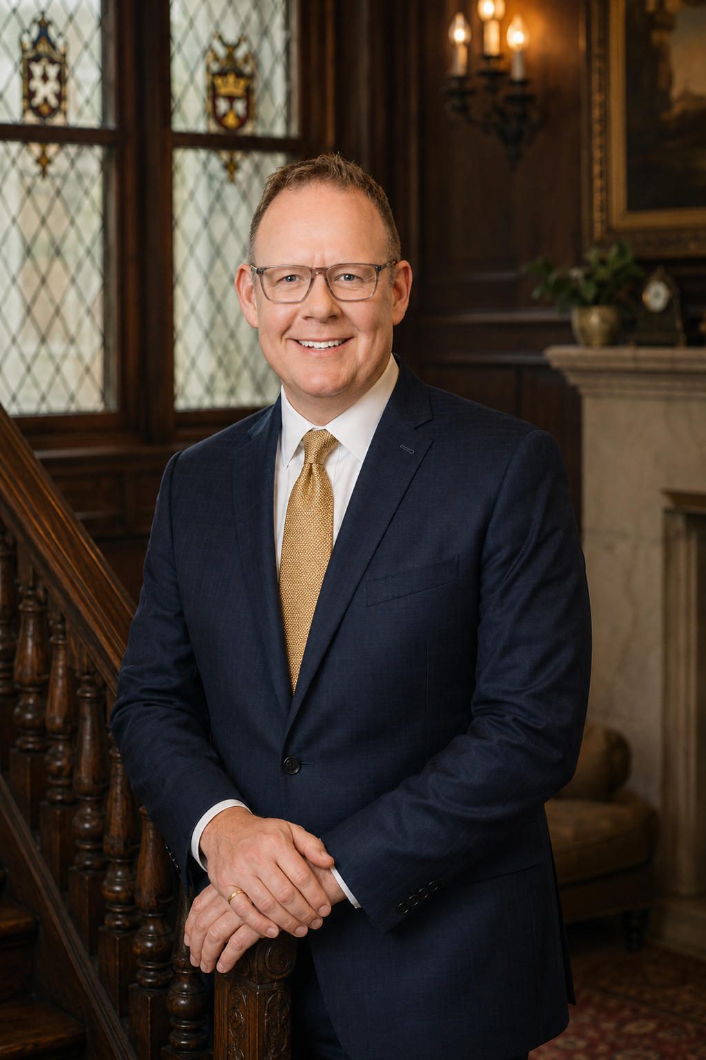 Smiling man in suit by wood-paneled staircase